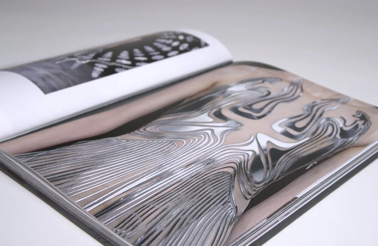 Close-up of a Materials spread showing one of Iris's metallic dresses photographed against pink paper