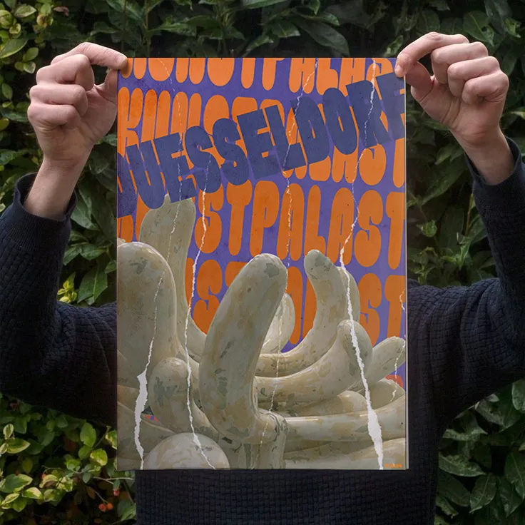 Hands holding the Kunstpalast poster outdoors against green hedge background.